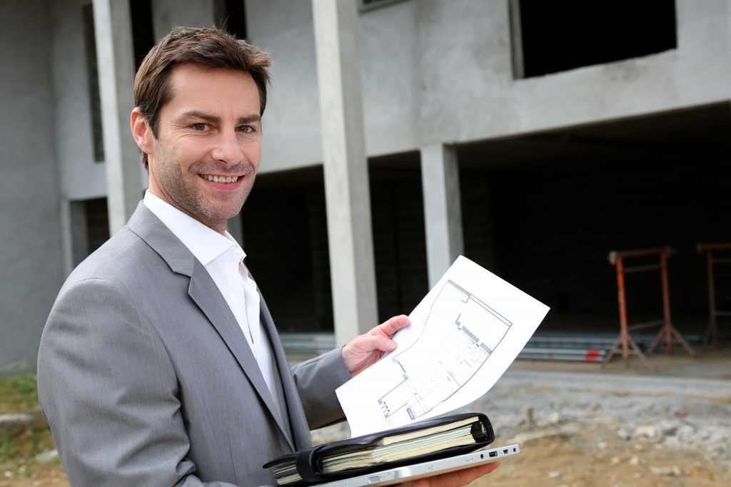 real estate agent holding a house design plan