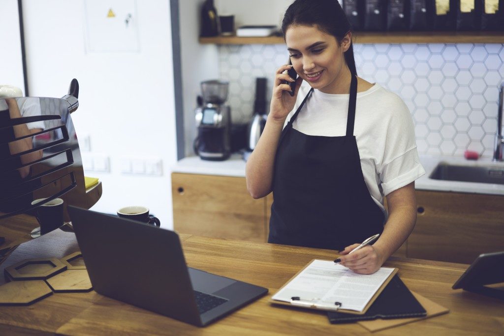 Entrepreneur dressed in black apron with mock up making coffee business by herself