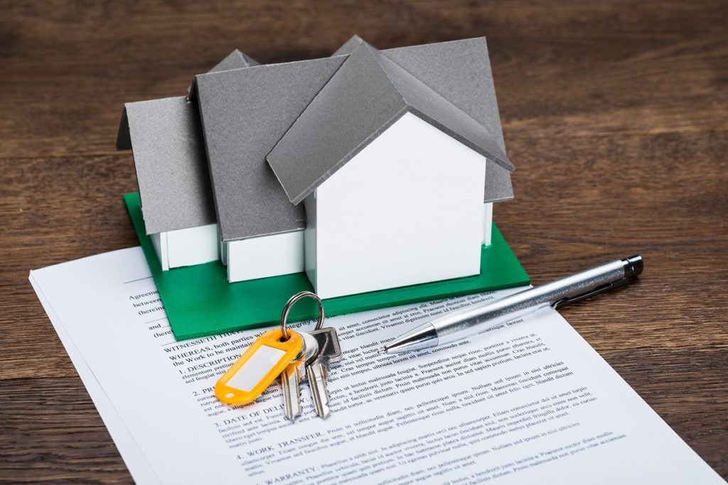 miniature house on top of a mortage loan document