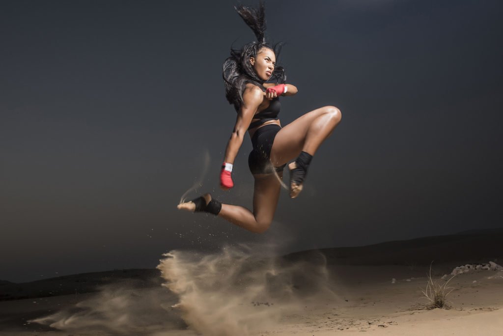 woman kickboxing in the sand