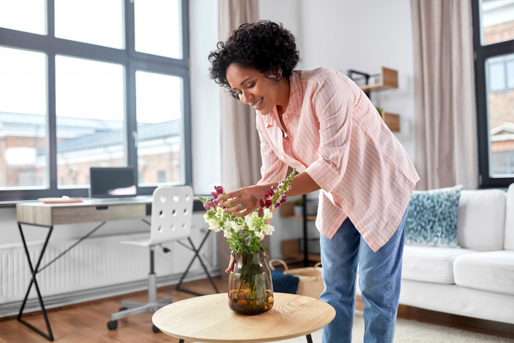 woman decorating flower base in the room