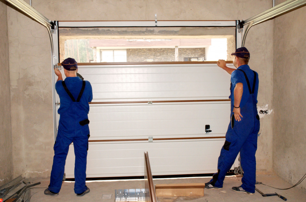 Two handymen installing an insulated garage door