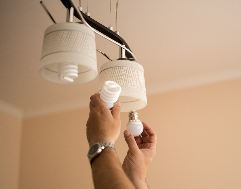 man changing old light bulb with a LED light bulb