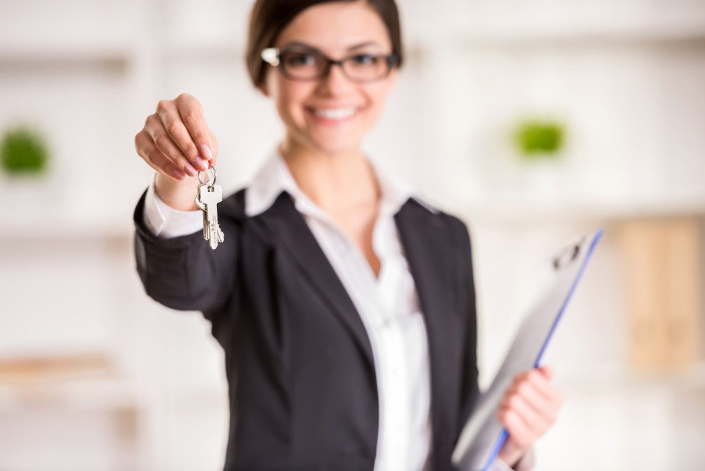female agent holding keys to an apartment