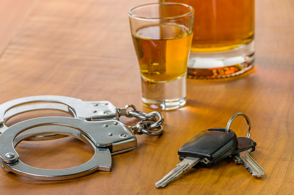 DUI concept alcohol with car keys and handcuffs