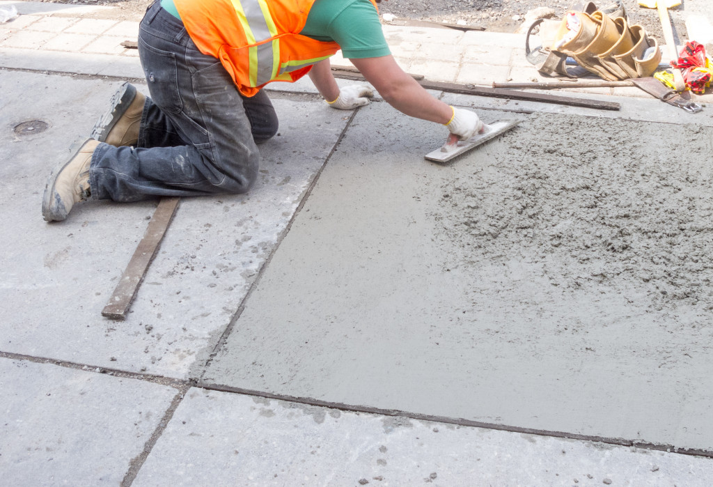 A worker repairing a sidewalk