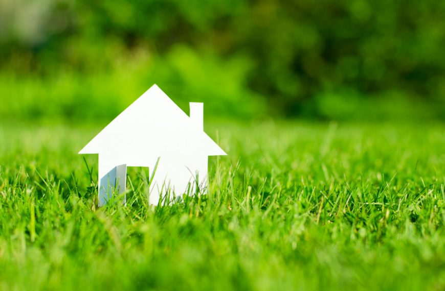 model house in a green field representing property investments