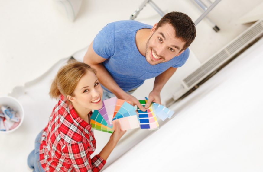 couple repainting the wall of their house